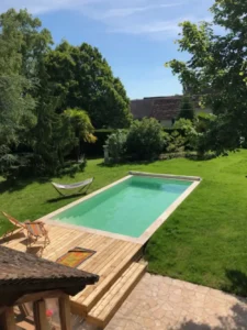 Piscine rectangulaire dans jardin verdoyant ensoleillé