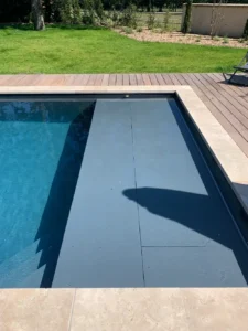 Piscine moderne avec terrasse en bois et jardin