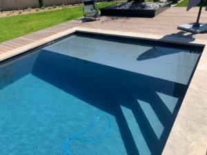 Piscine moderne avec volet immergé et terrasse bois