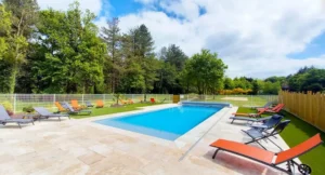 Piscine extérieure avec transats dans jardin arboré