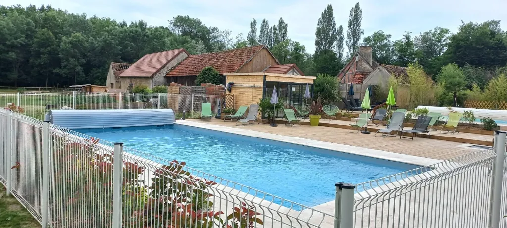 Piscine extérieure avec terrasse en bois et transats