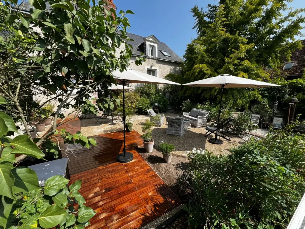 Jardin aménagé avec terrasse en bois et parasols