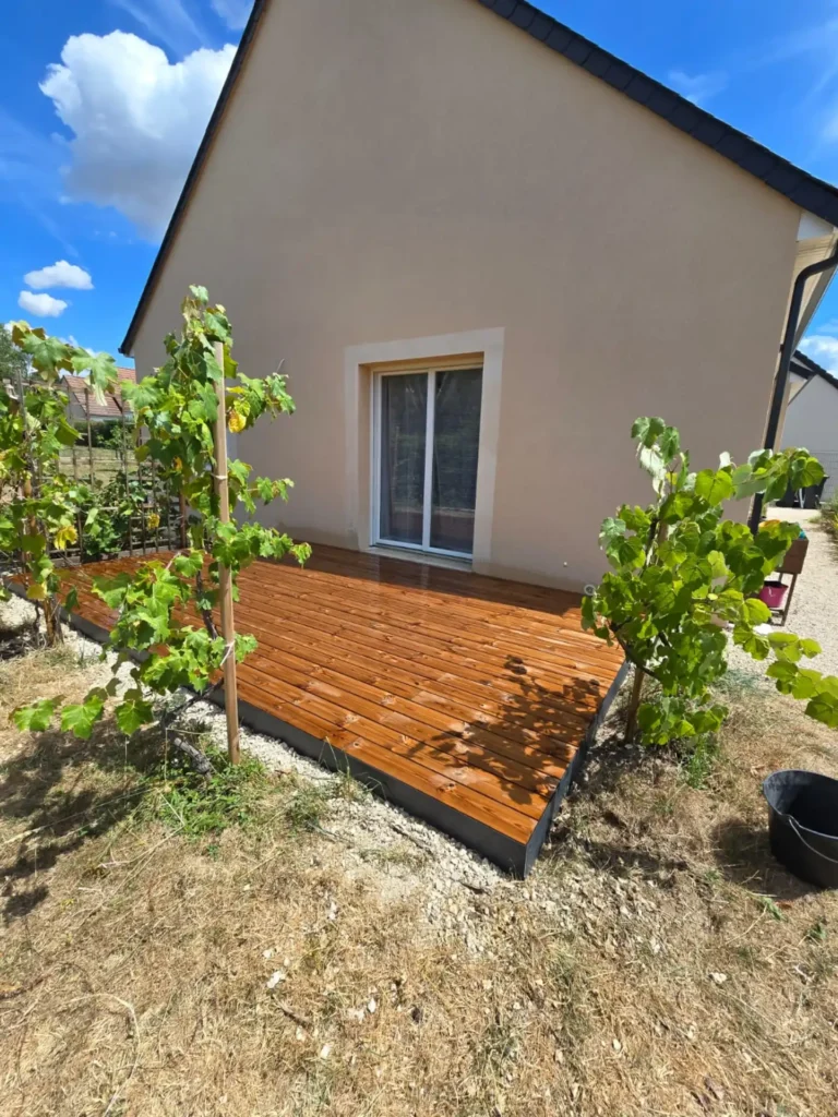 Terrasse en bois devant maison beige moderne