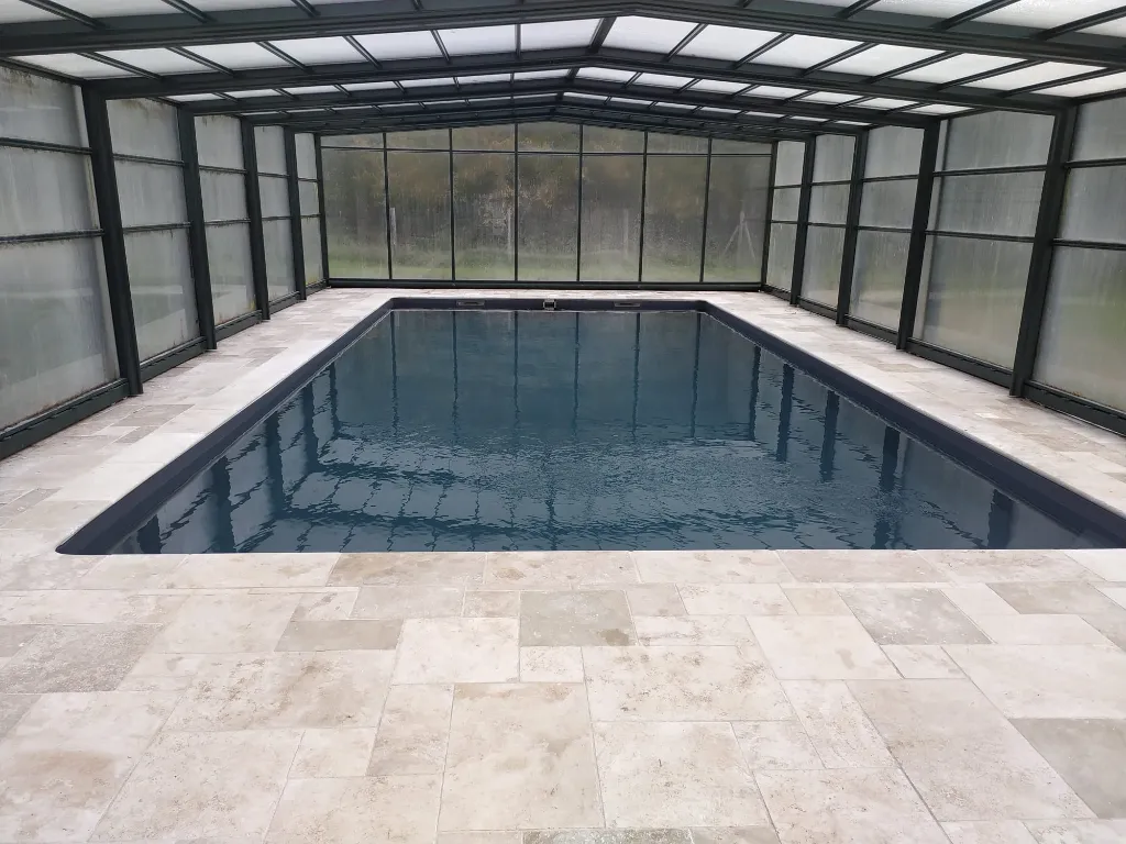 Piscine intérieure rectangulaire sous véranda vitrée