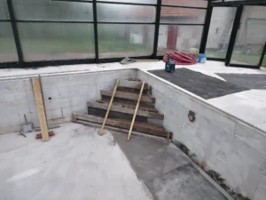 Piscine intérieure en rénovation avec escalier en construction