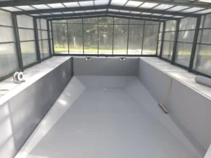 Piscine intérieure vide sous véranda vitrée