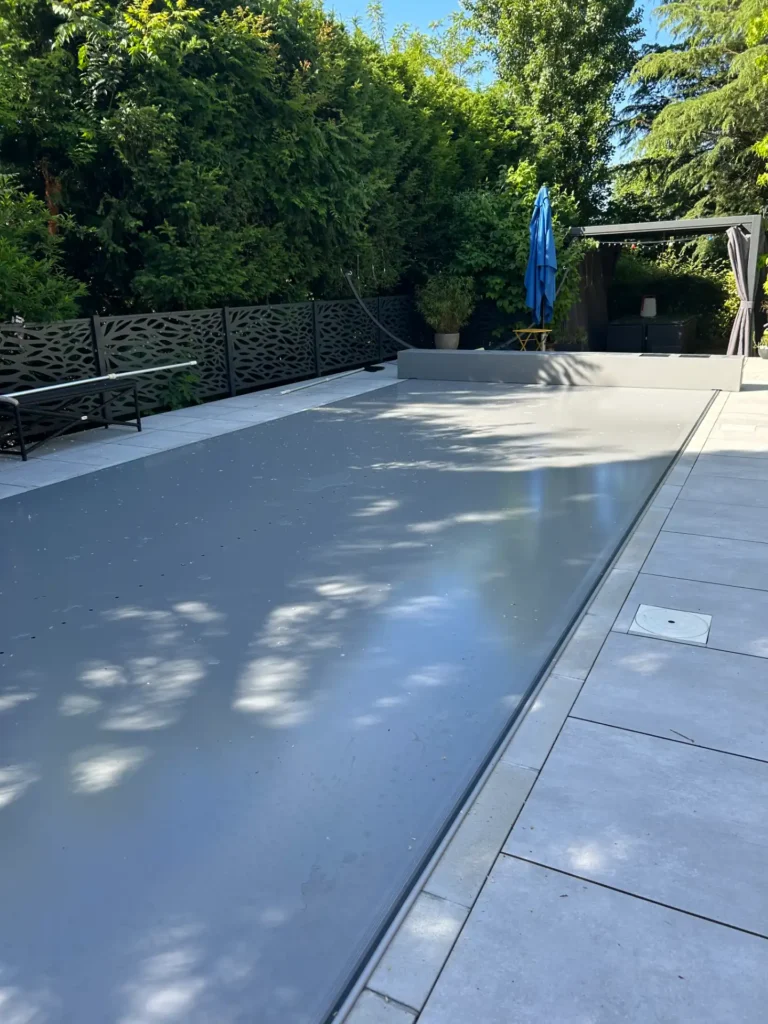Piscine moderne avec couverture et terrasse arborée