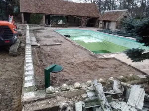 Piscine vidée en rénovation dans un jardin