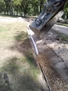 Pelleteuse creusant une tranchée avec gravier
