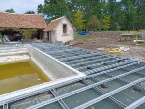 Chantier de piscine avec structure métallique extérieure